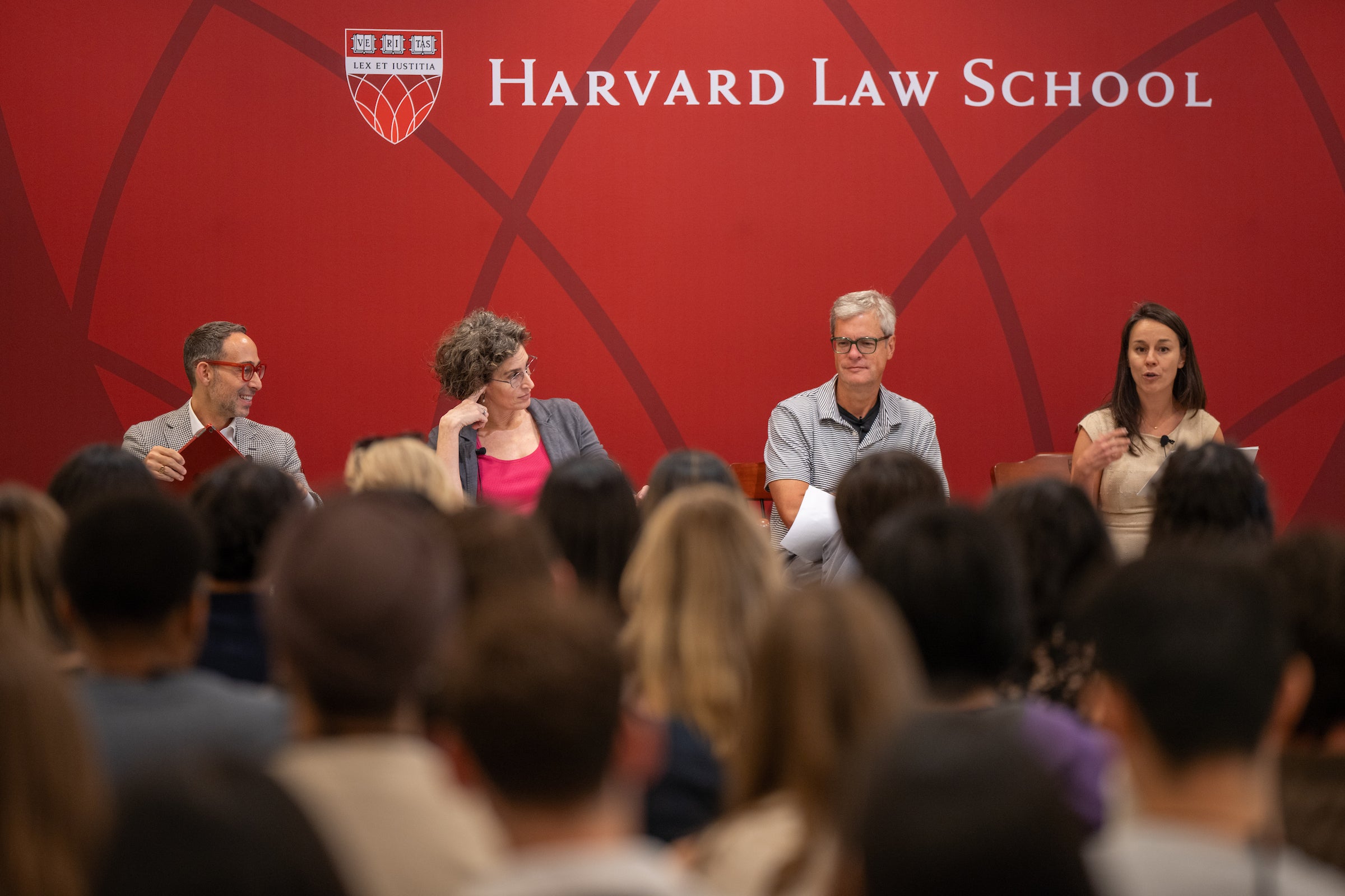 Panelists speak in front of the Harvard Law School backdrop during a pre-orientation event.