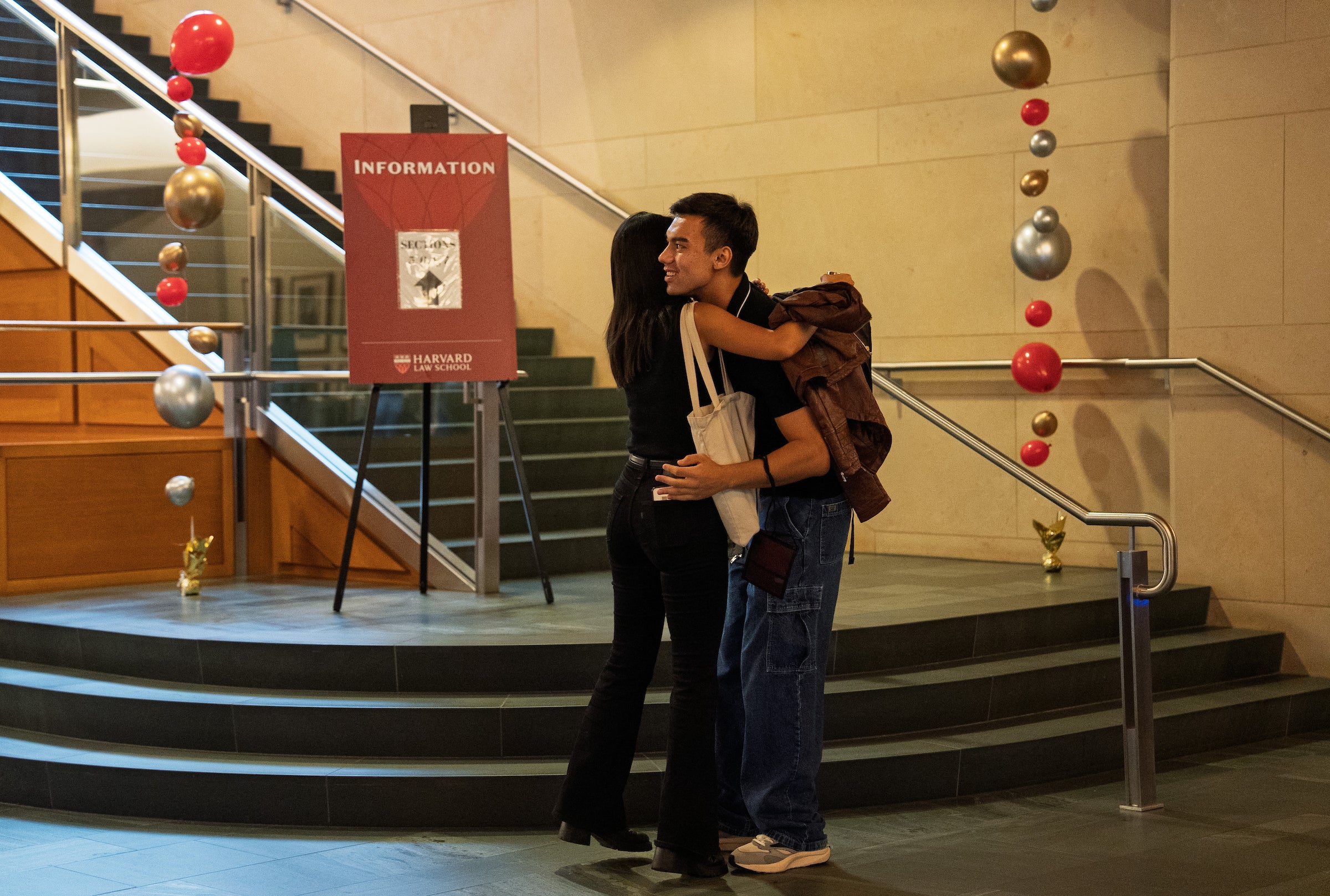 Classmates exchange a hug near the main steps in the WCC during orientation.