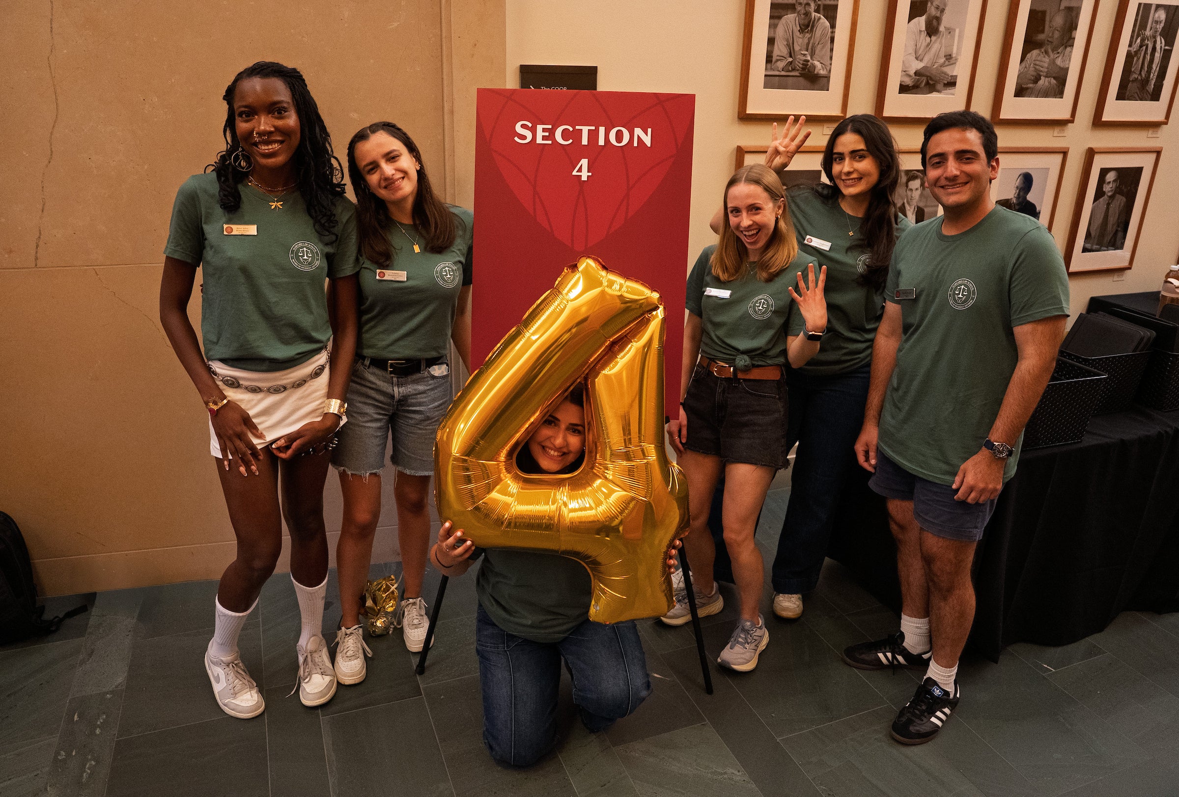 Students in section 4 pose in front of a section four sign and balloon.