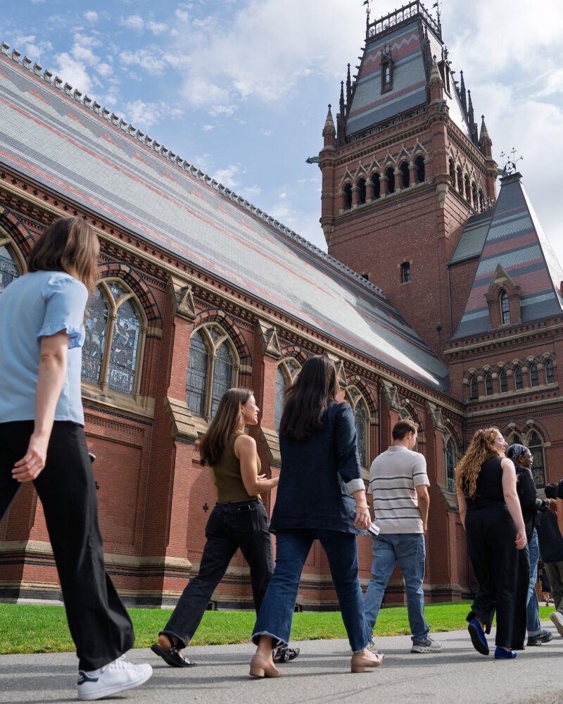 Students walk along the side of Memorial Hall on their way to Sanders Theatre for an orientation event.
