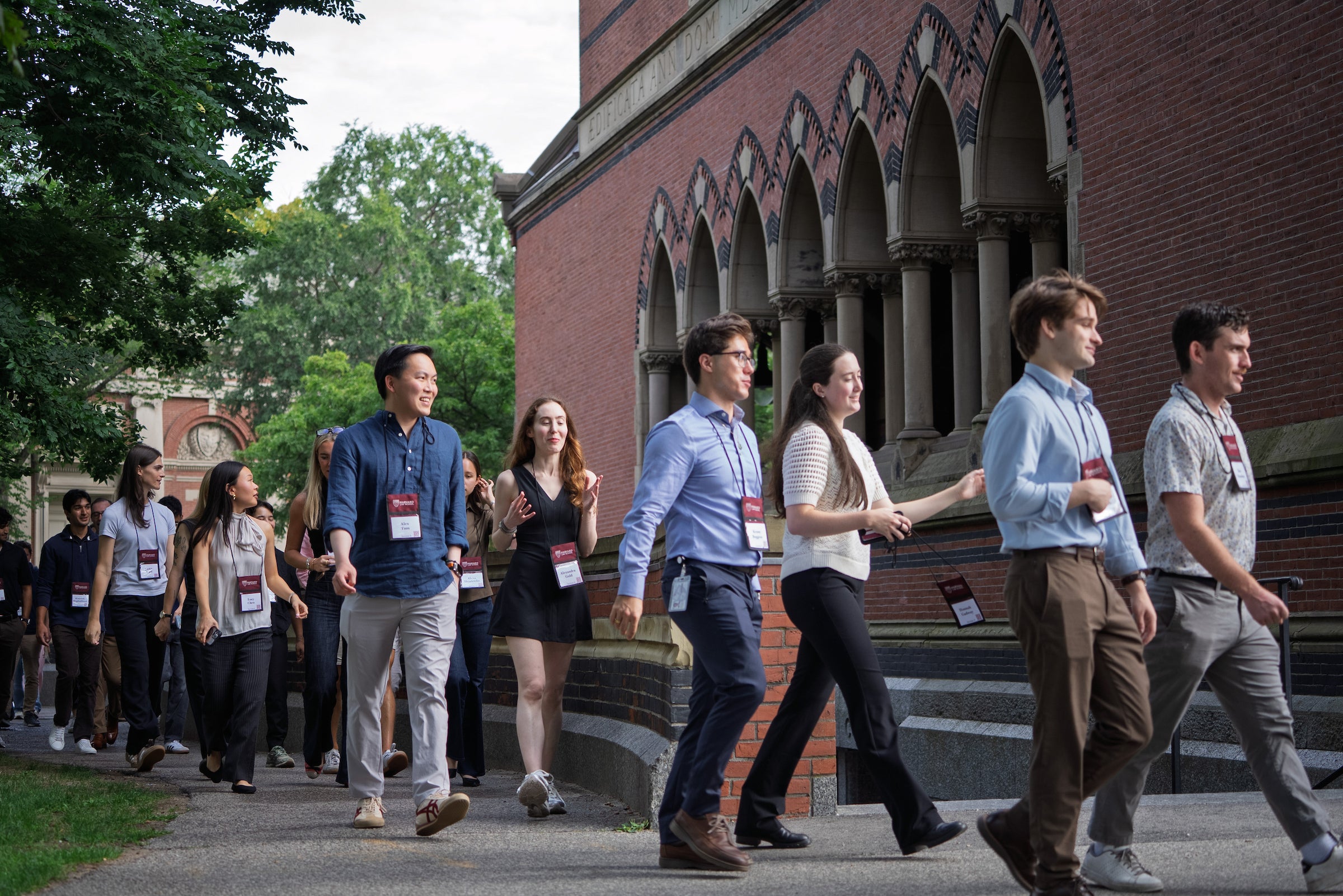 Students process along a path near Memorial Hall on their way to Sanders Theatre during orientation.
