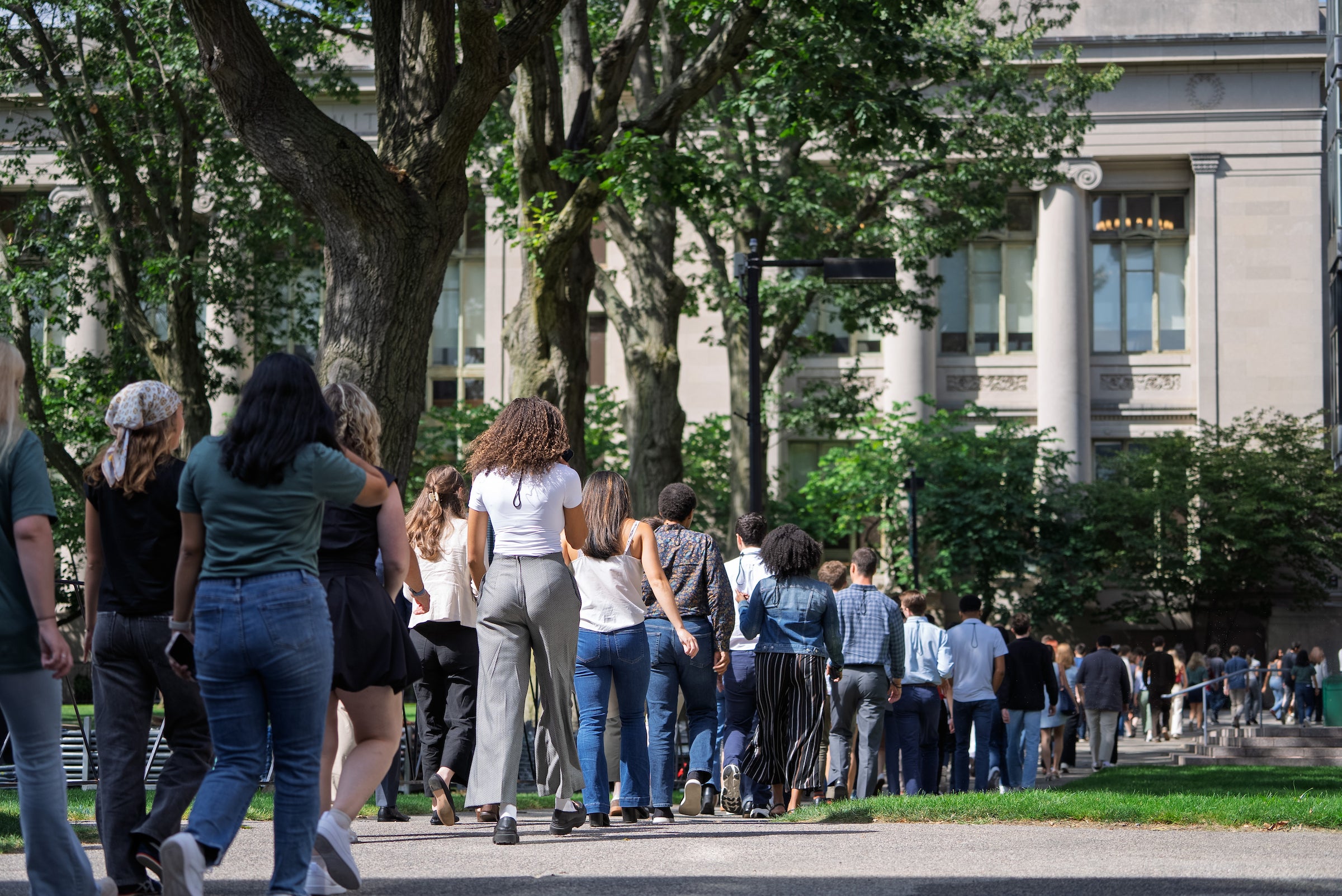 Students return to campus towards Langdell Hall following an orientation event at Sanders Theatre.