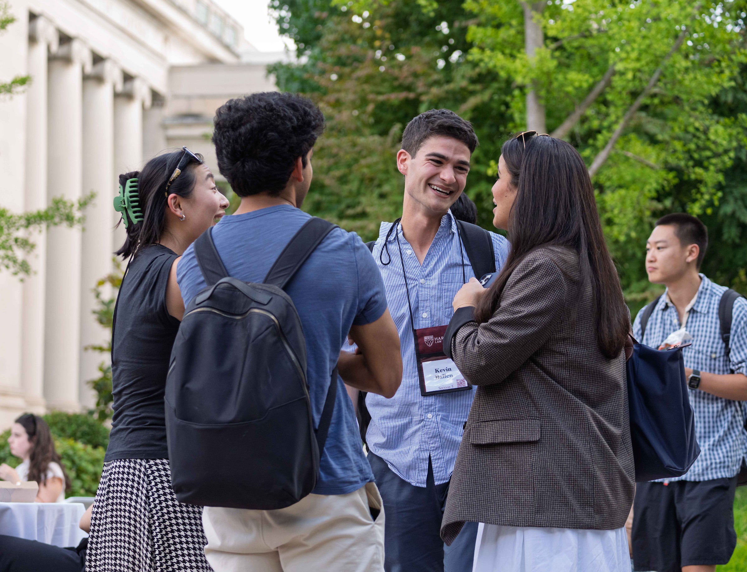 Four students chat outside on campus during orientation.
