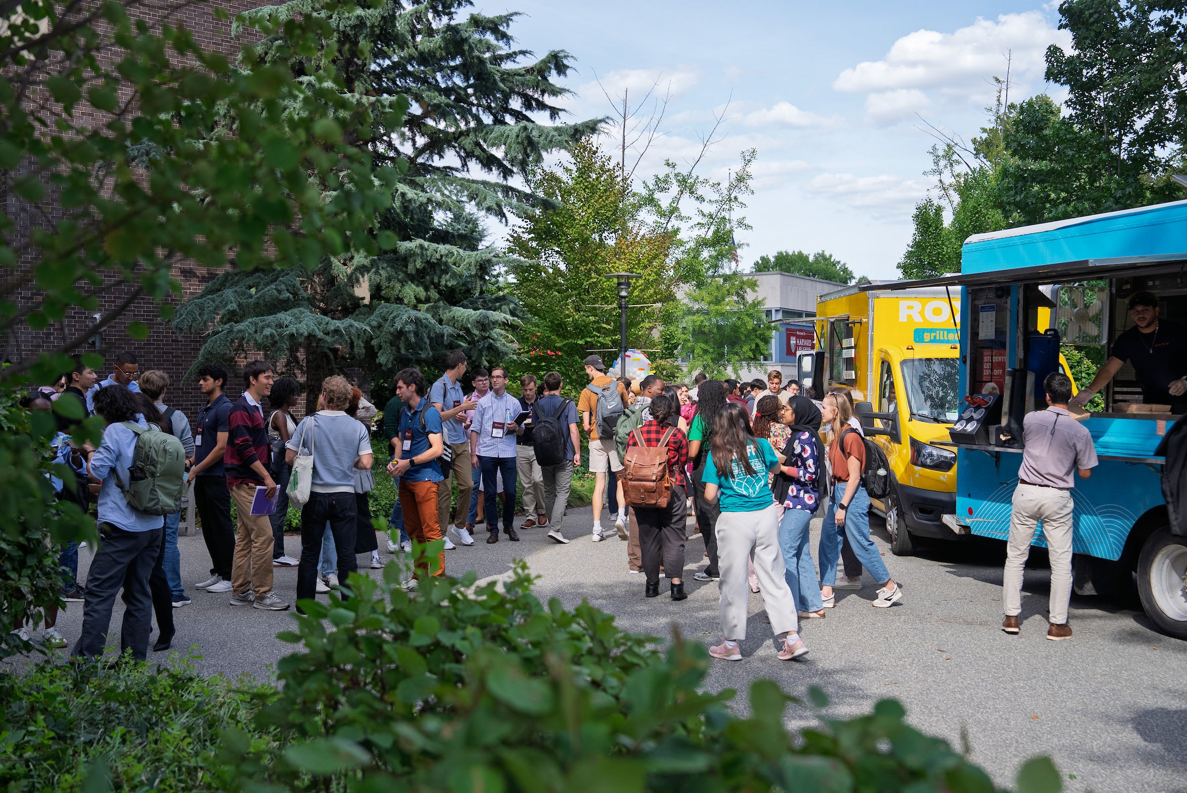 Students gather around food truck outside on campus during orientation.