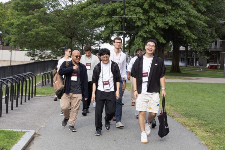 A group of students walk along a path on campus towards an orientation event at Memorial Hall.