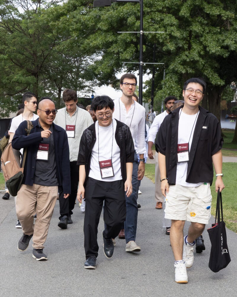 A group of students walk along a path on campus towards an orientation event at Memorial Hall.