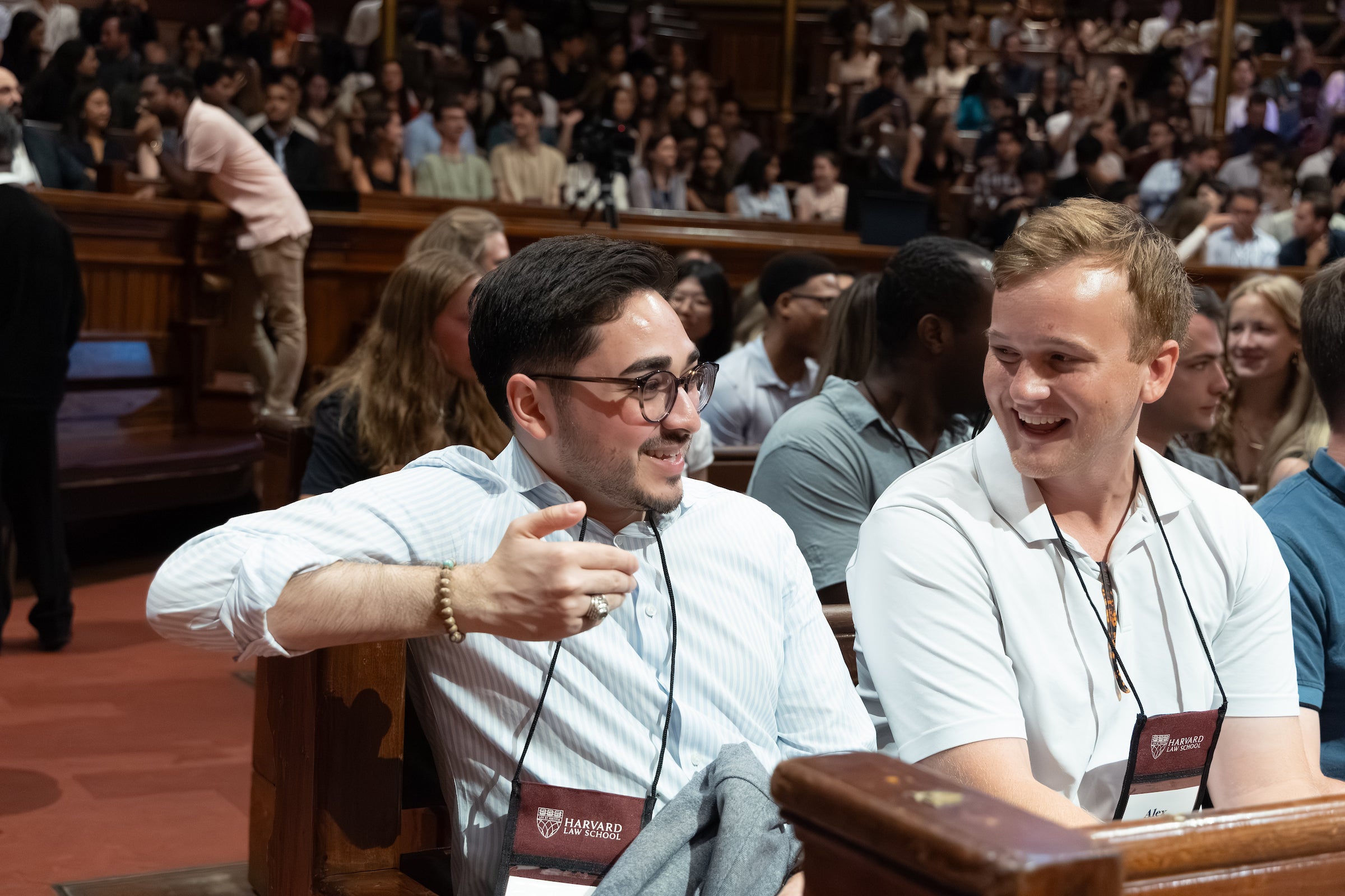 Two student chat in the audience of Sanders Theatre.