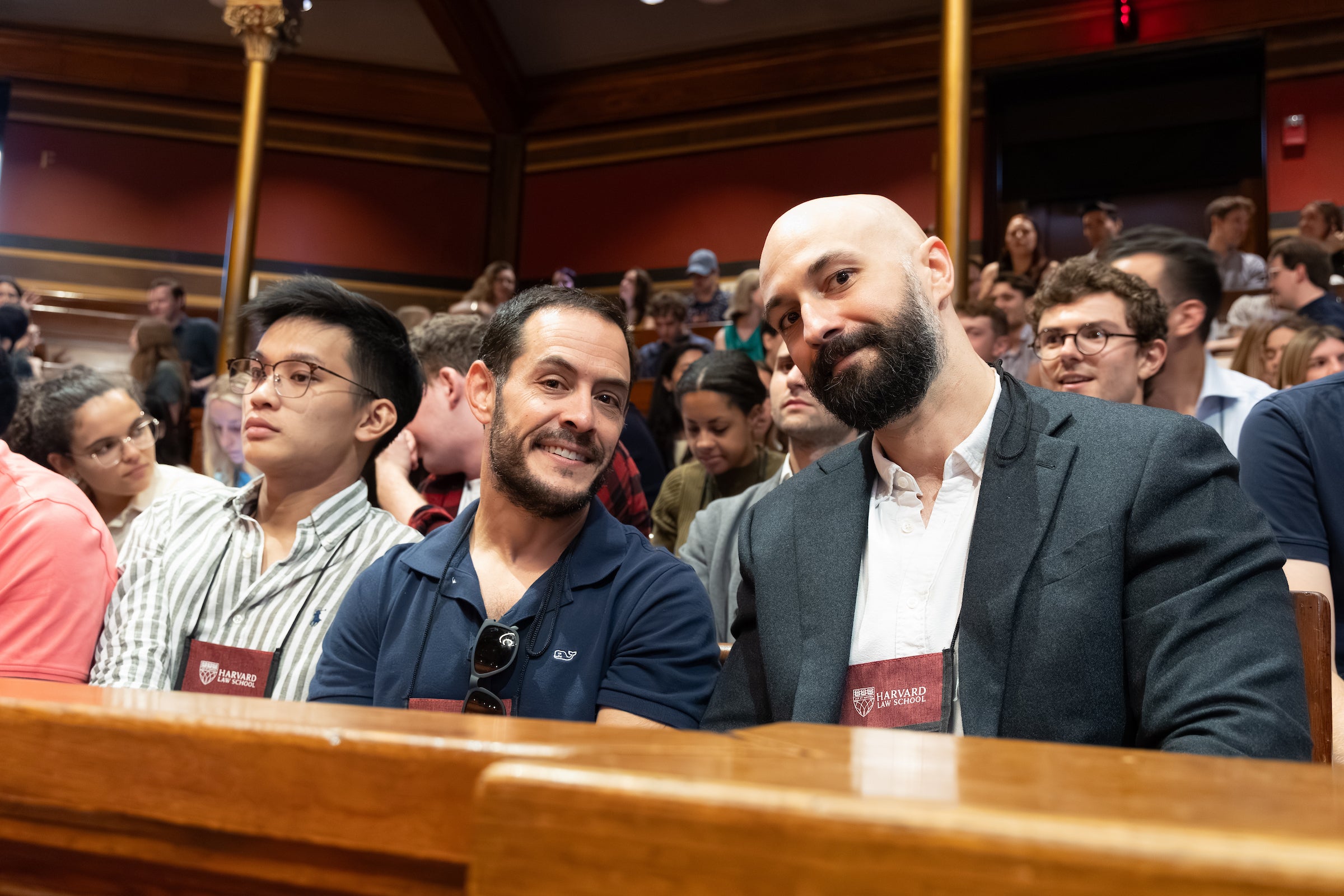 Two students smiling in the front row of an event.