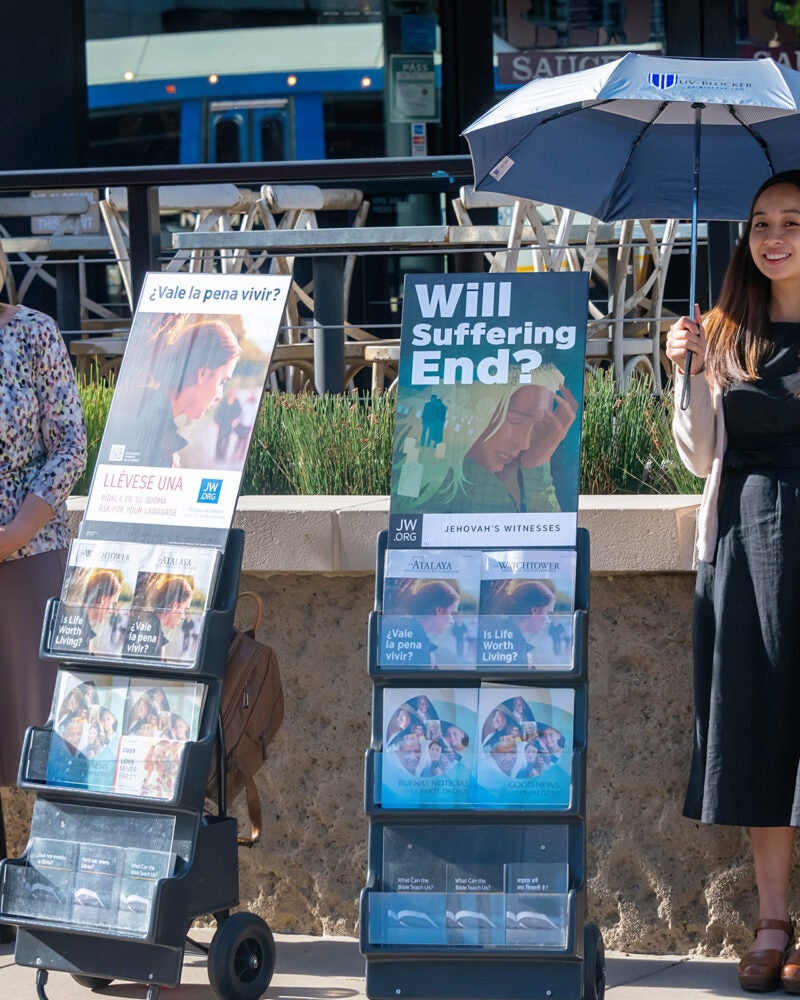 Two women standing next to pamphlet displays.