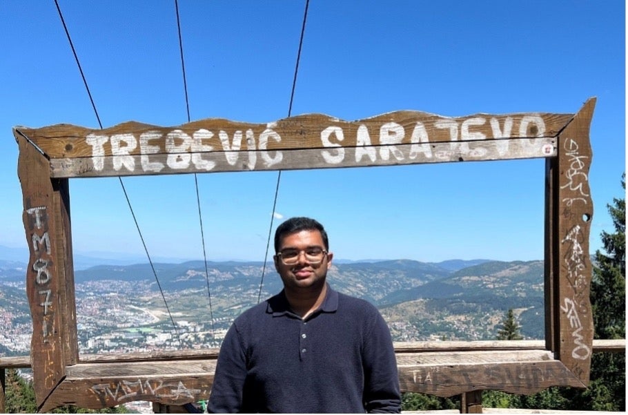 Man with aerial view of Sarajevo in the background.