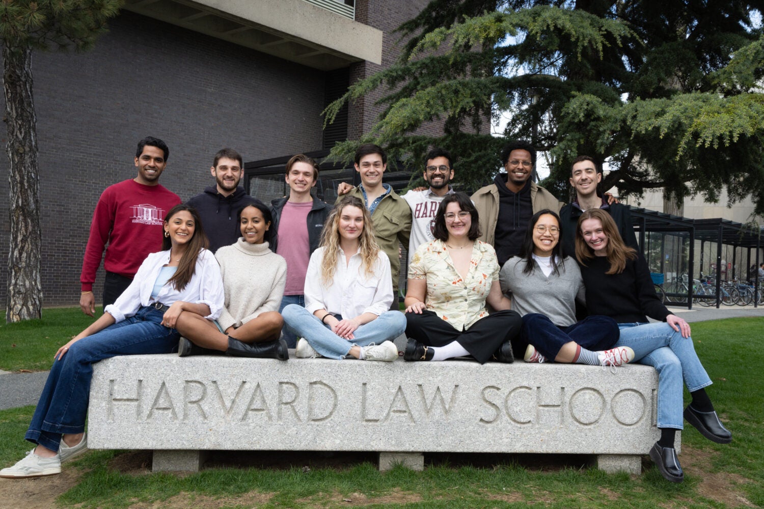 A group of HLS students posed for a photo around a sign that says