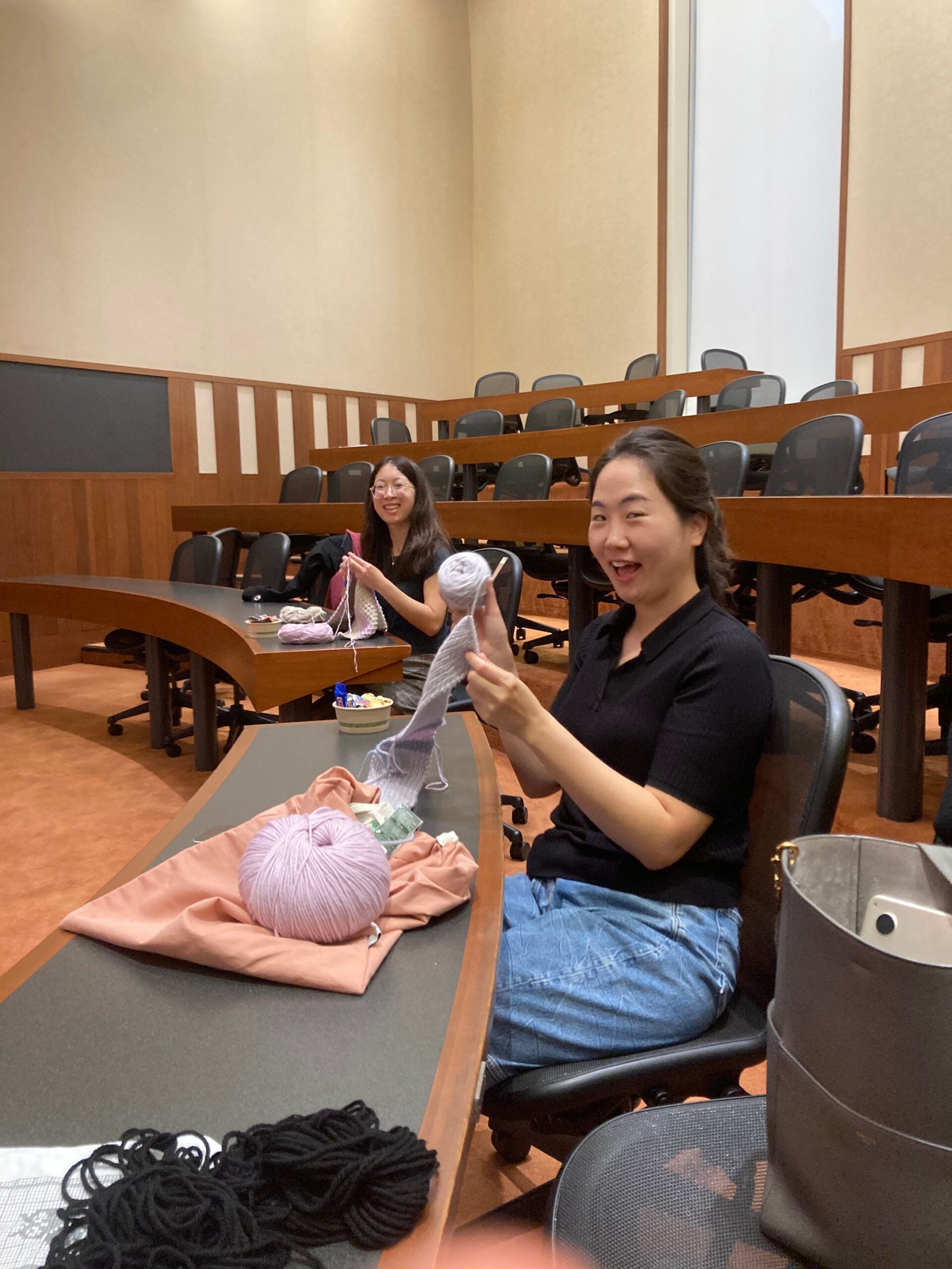 Woman holds up her knitting project.