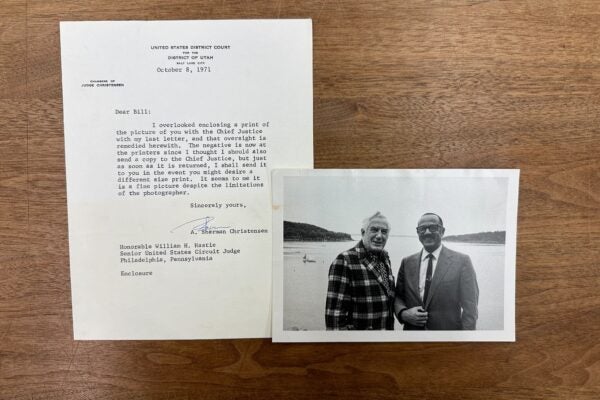 William Hastie and Chief Justice Earl Warren smiling and standing together in front of a large body of water. A typewritten letter accompanying the photograph from A. Sherman Christensen.