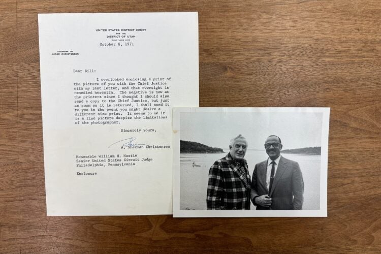 William Hastie and Chief Justice Earl Warren smiling and standing together in front of a large body of water. A typewritten letter accompanying the photograph from A. Sherman Christensen.