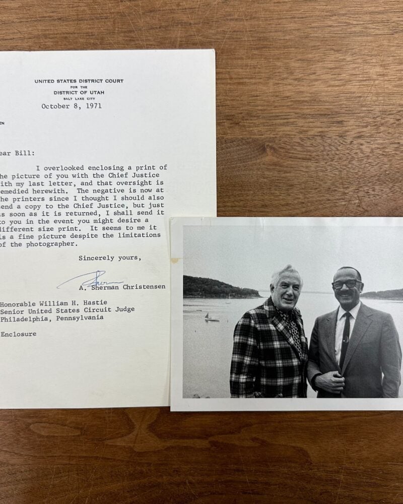 William Hastie and Chief Justice Earl Warren smiling and standing together in front of a large body of water. A typewritten letter accompanying the photograph from A. Sherman Christensen.
