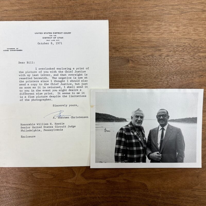 William Hastie and Chief Justice Earl Warren smiling and standing together in front of a large body of water. A typewritten letter accompanying the photograph from A. Sherman Christensen.