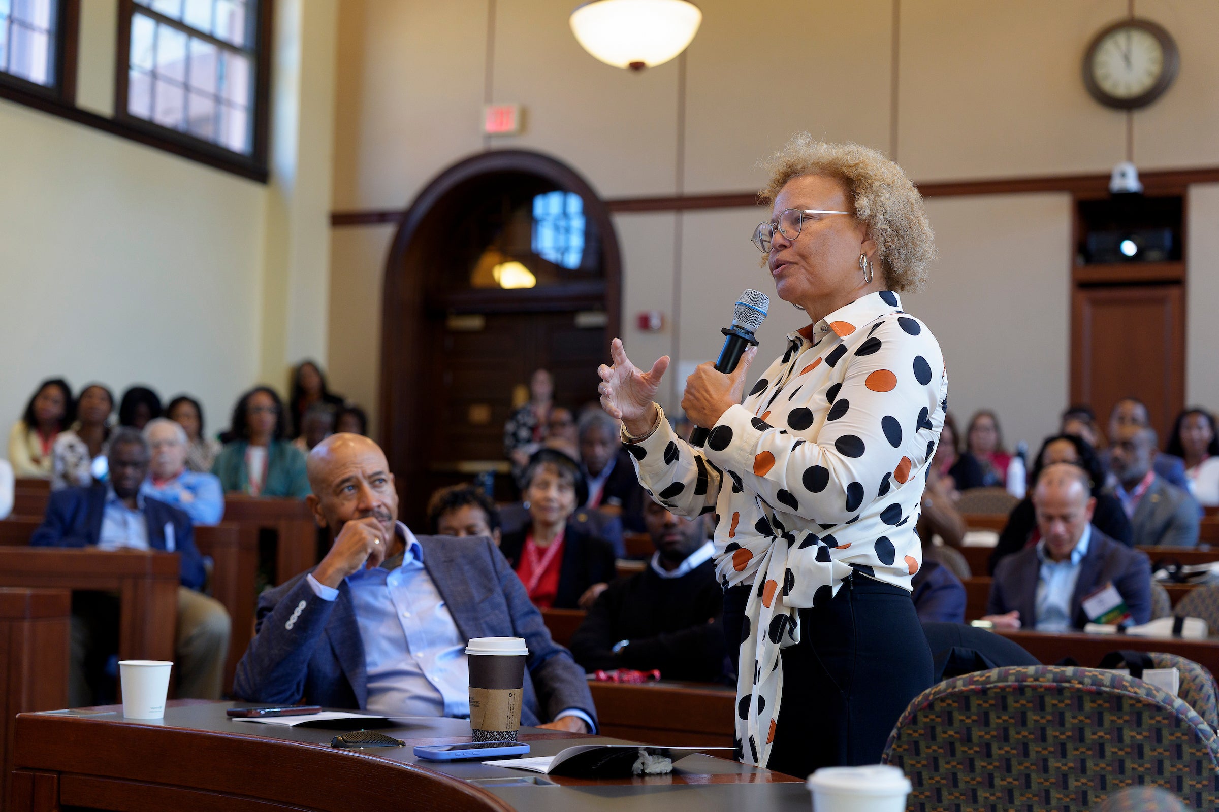 A woman asking a question in a classroom.