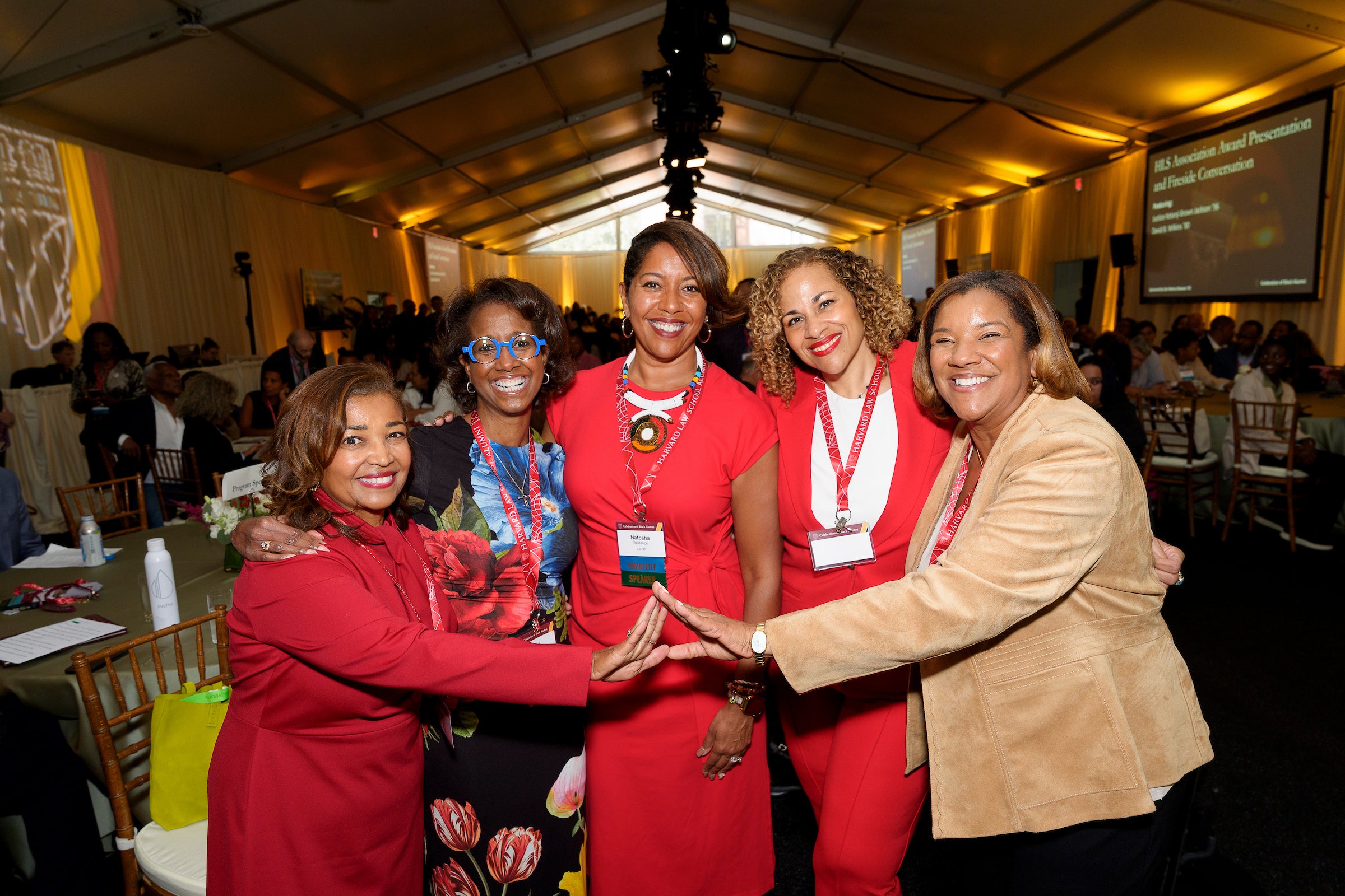 Five women posing for a group photo at an event.