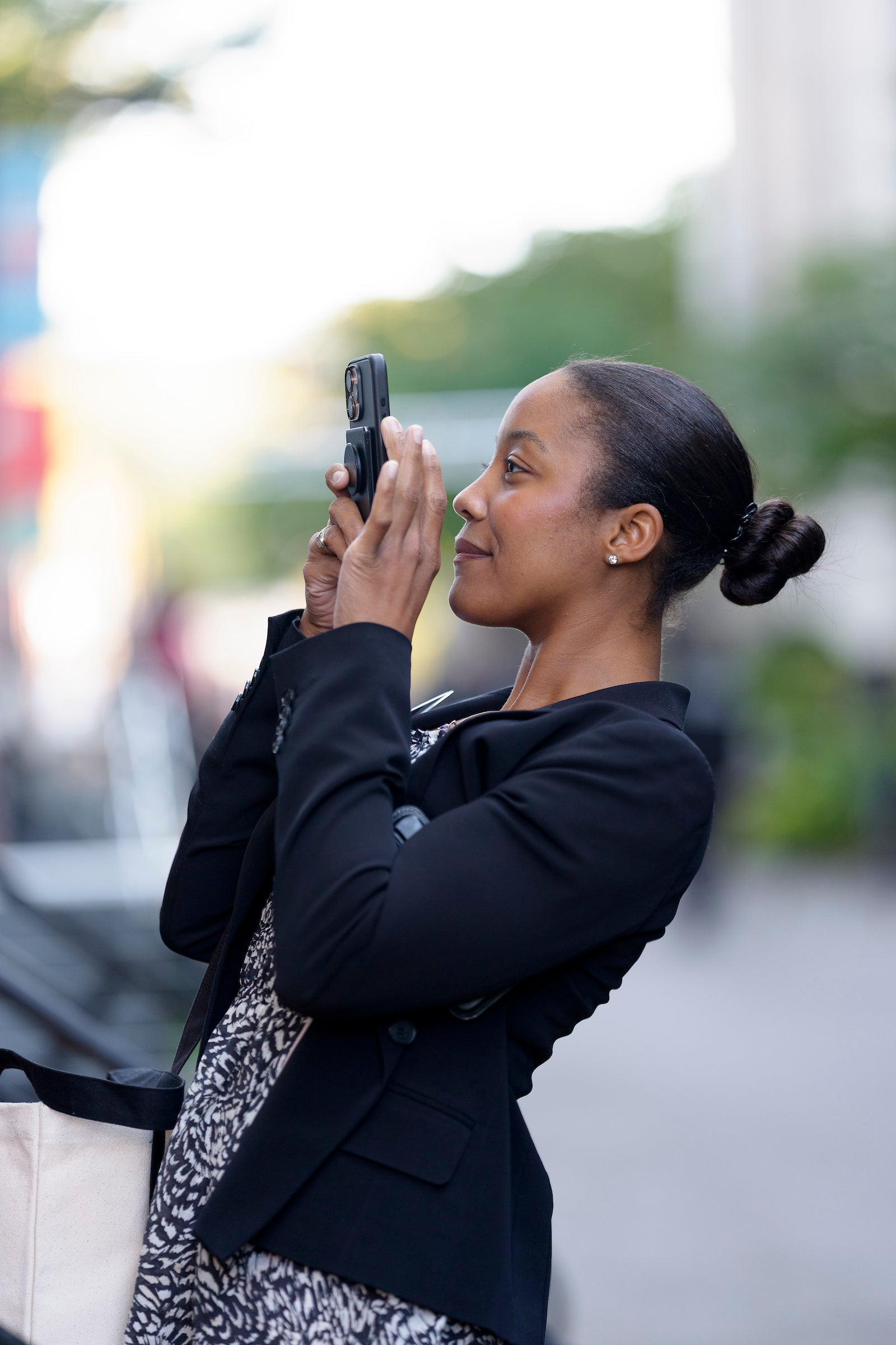 A woman takes a photo with her cell phone.