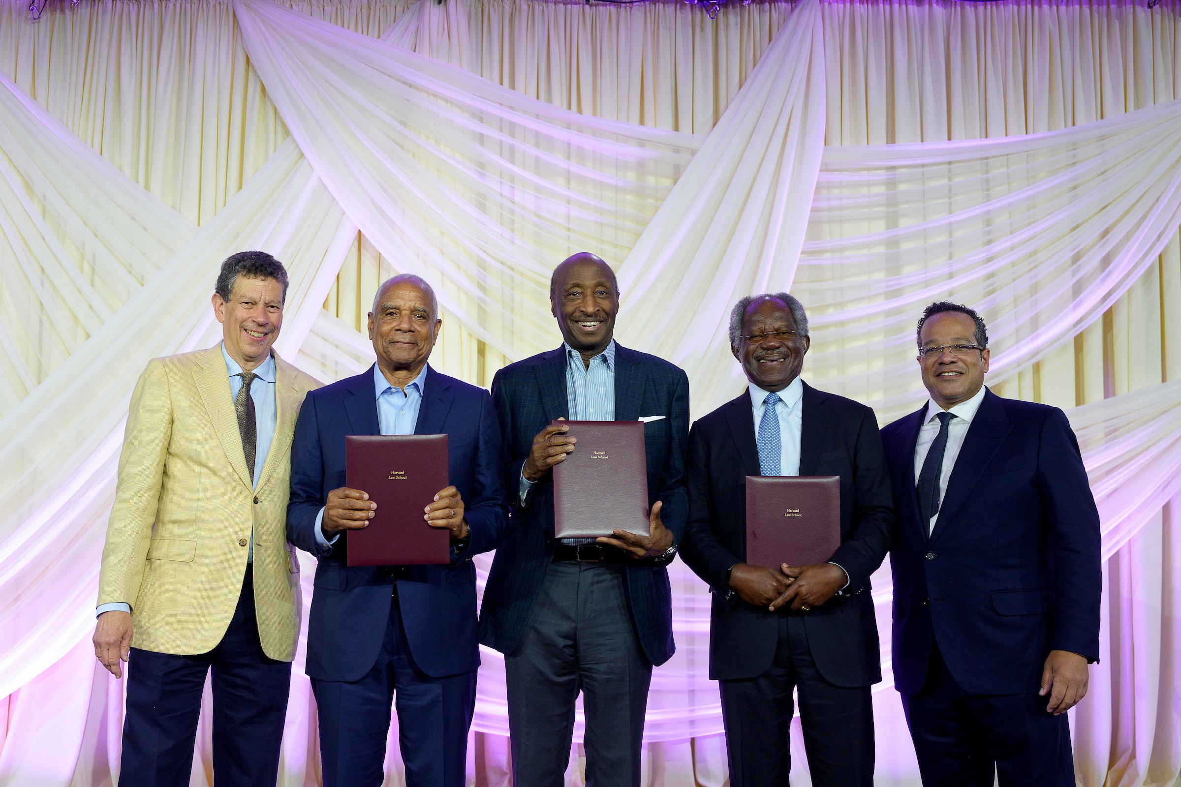 A group of men lined up on a stage holding awards.