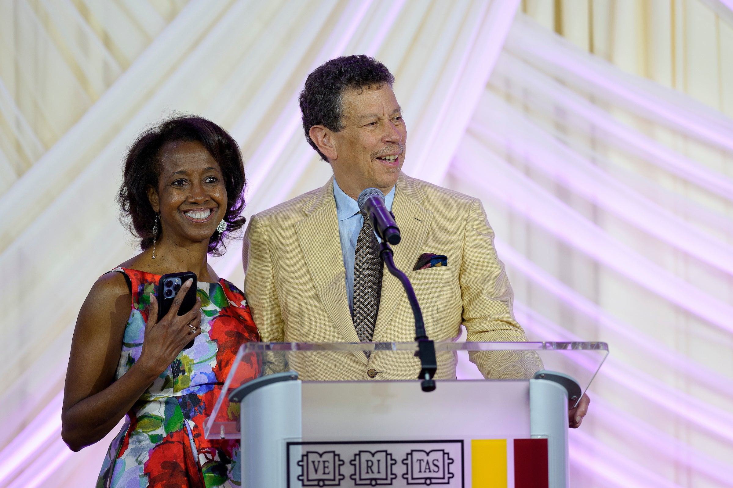 David Wilkins and a woman speak at the podium at an event.