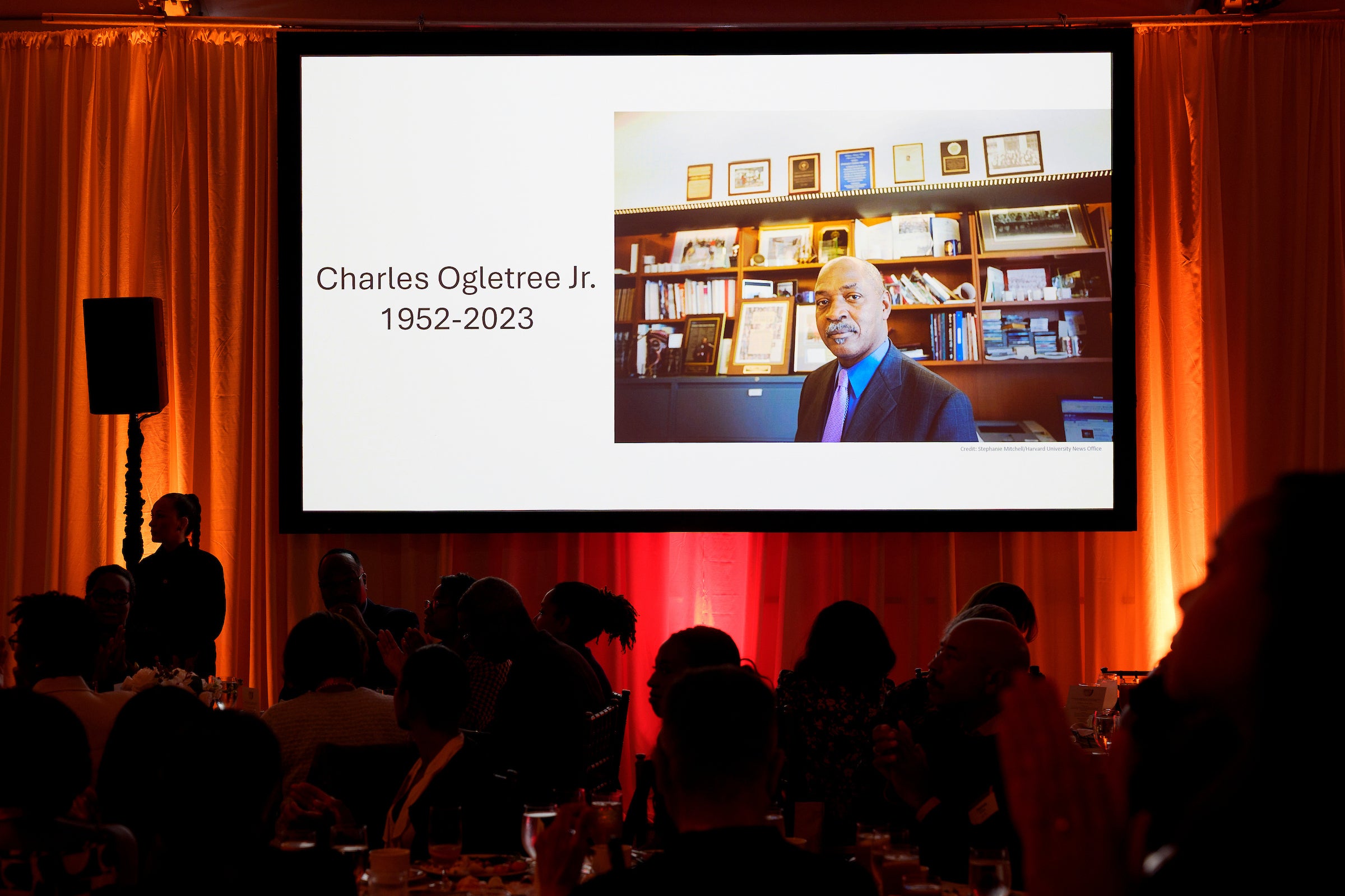 A photo of Charles Ogletree projected on a screen.
