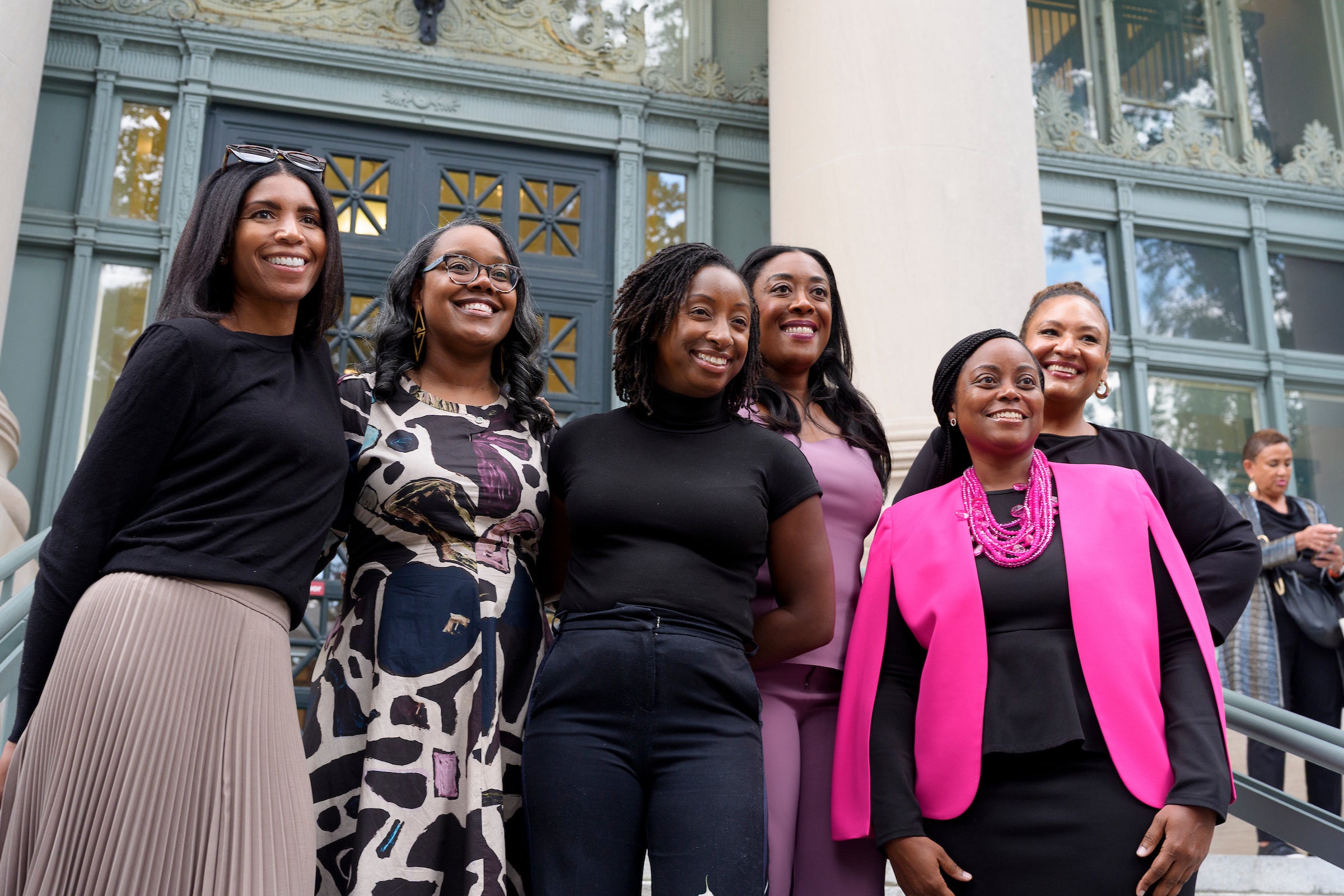 A group of women posing on the steps of a building.