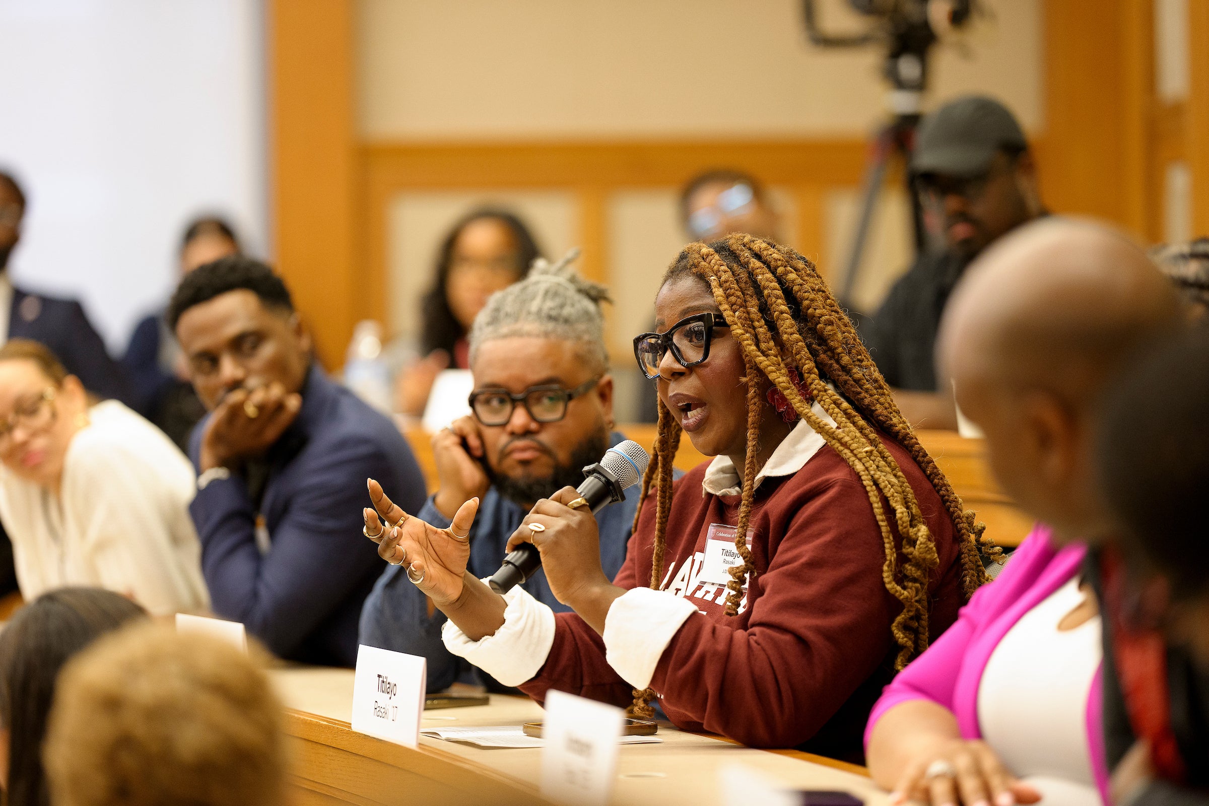 A woman asks a question in a classroom.