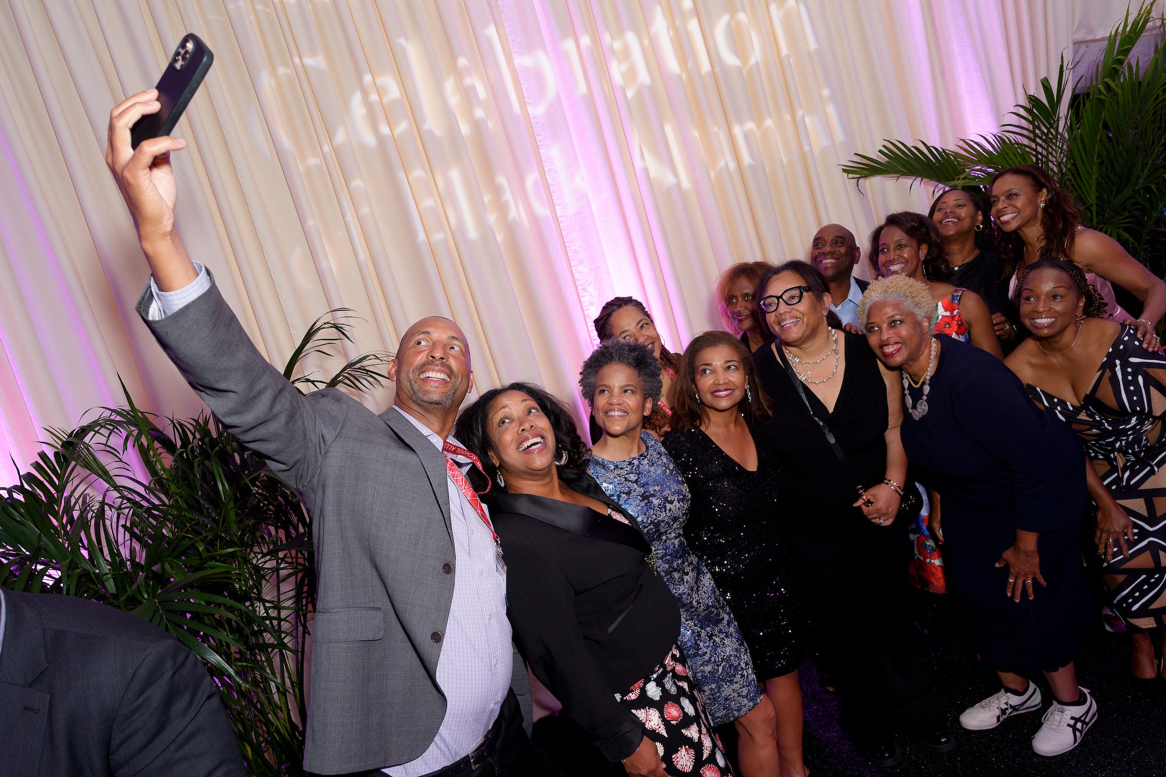 A man takes a selfie of a group of people at an event.