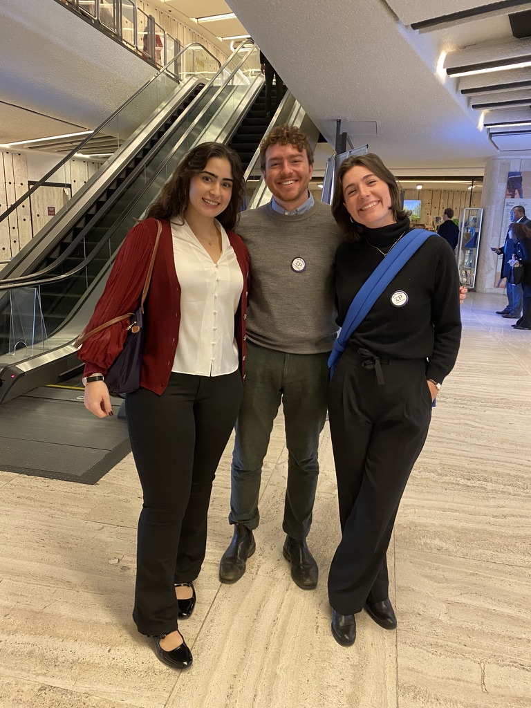 three students smile in a building
