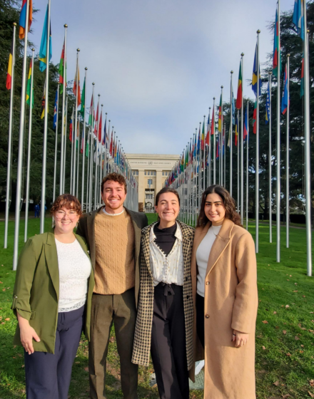 four people stand outside the UN in Geneva