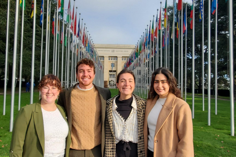 four people stand outside the UN in Geneva