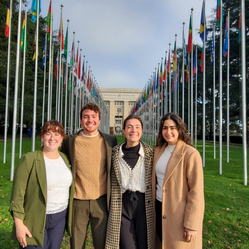 four people stand outside the UN in Geneva