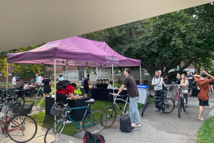 Students with bikes line up at a tent.