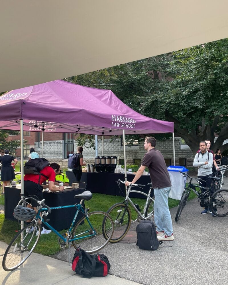 Students with bikes line up at a tent.