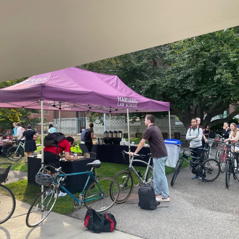 Students with bikes line up at a tent.