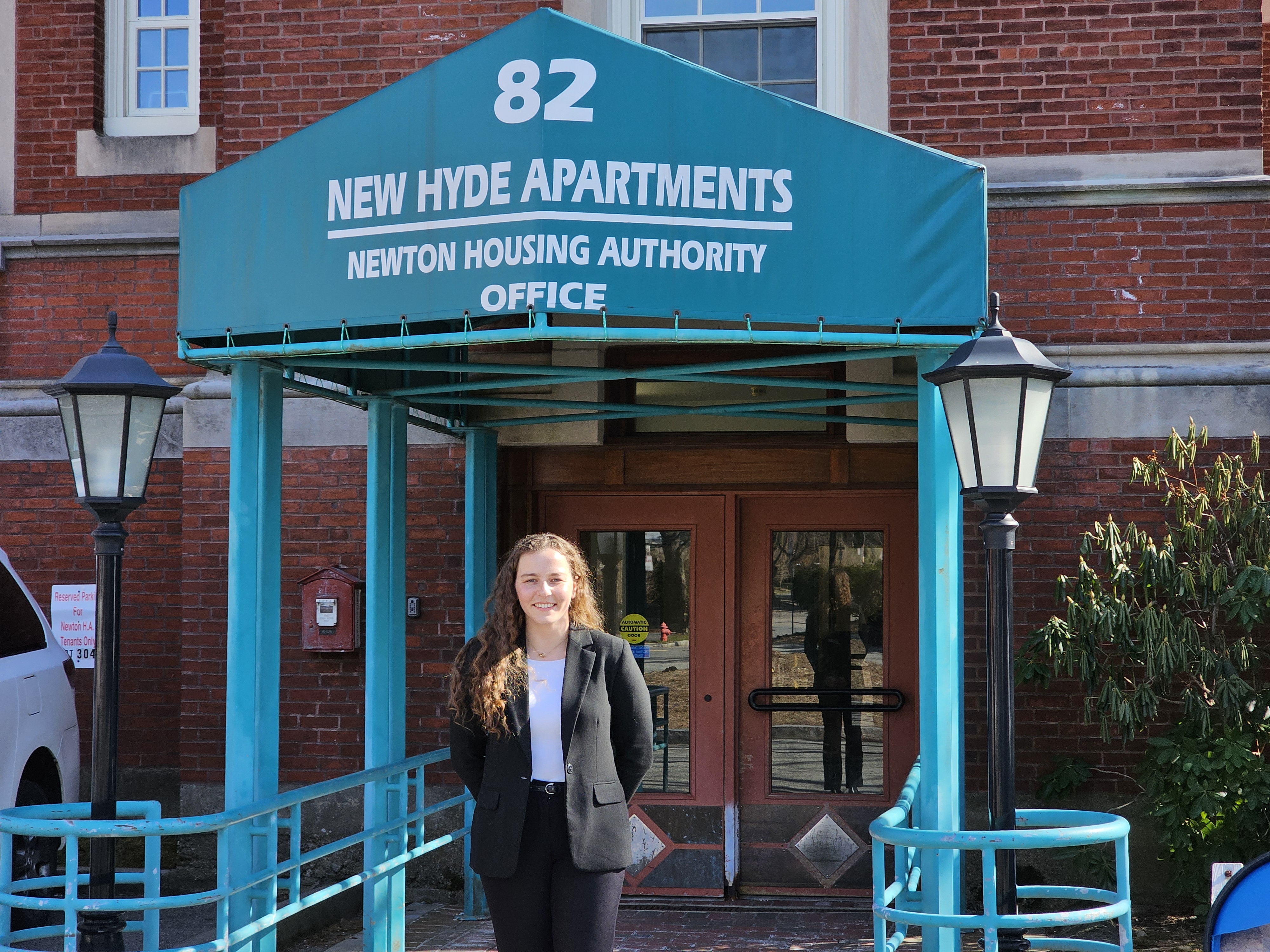 a student stands outside an apartment building