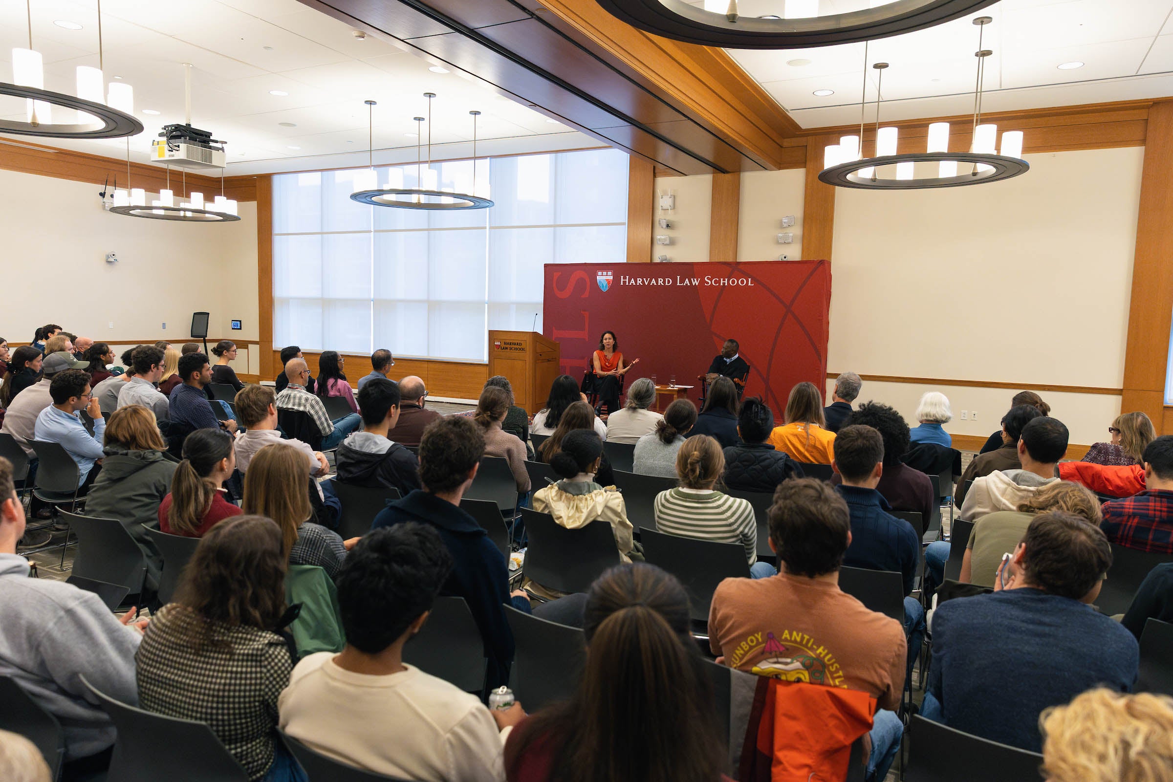 Emily Bazelon and Guy-Uriel Charles before a large audience.