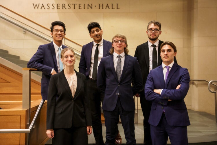 Six students from HLS Mock Trial Association pose for a group photo on the steps inside Wasserstein Hall.