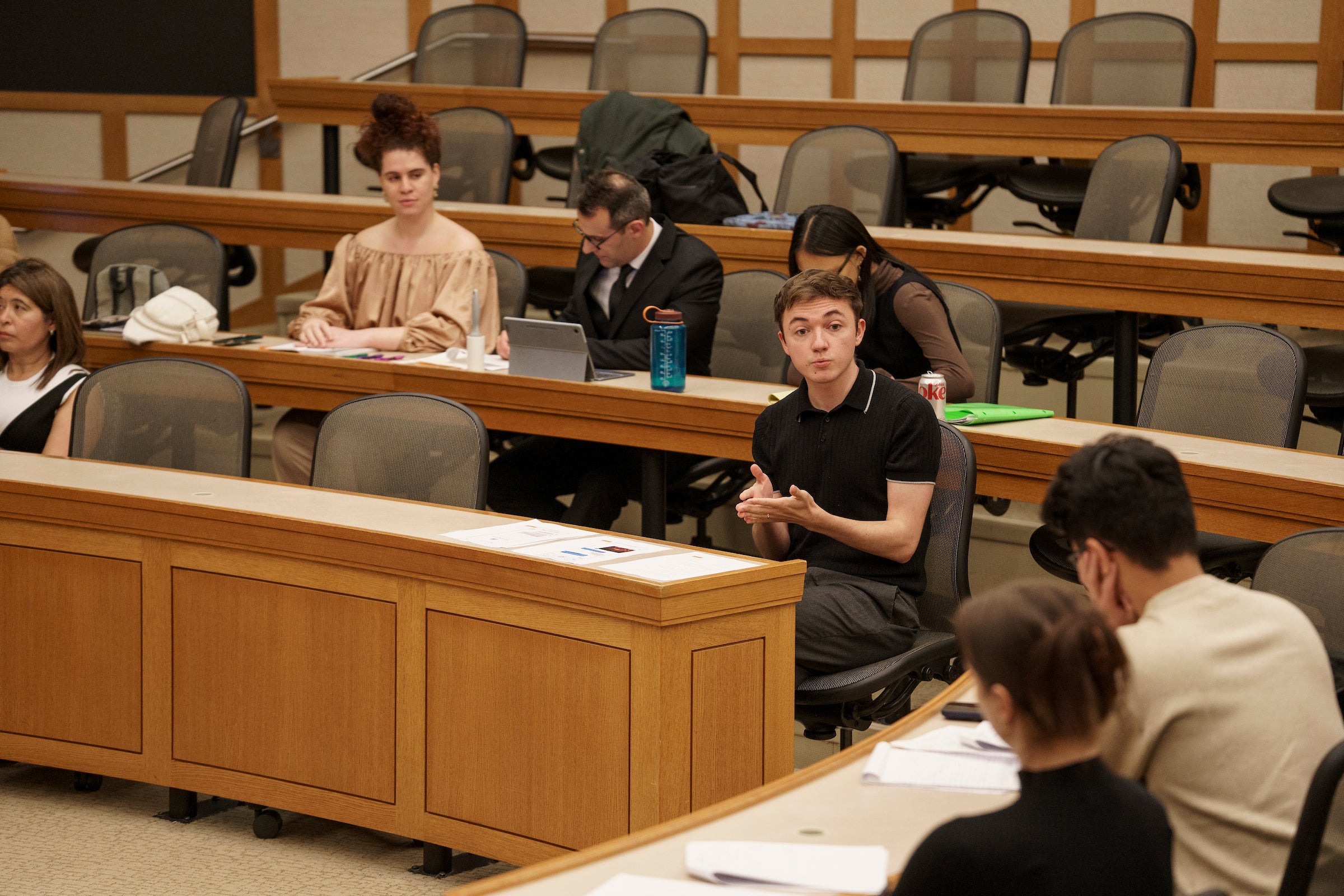 A classroom with students sitting at desks with papers in front of them.