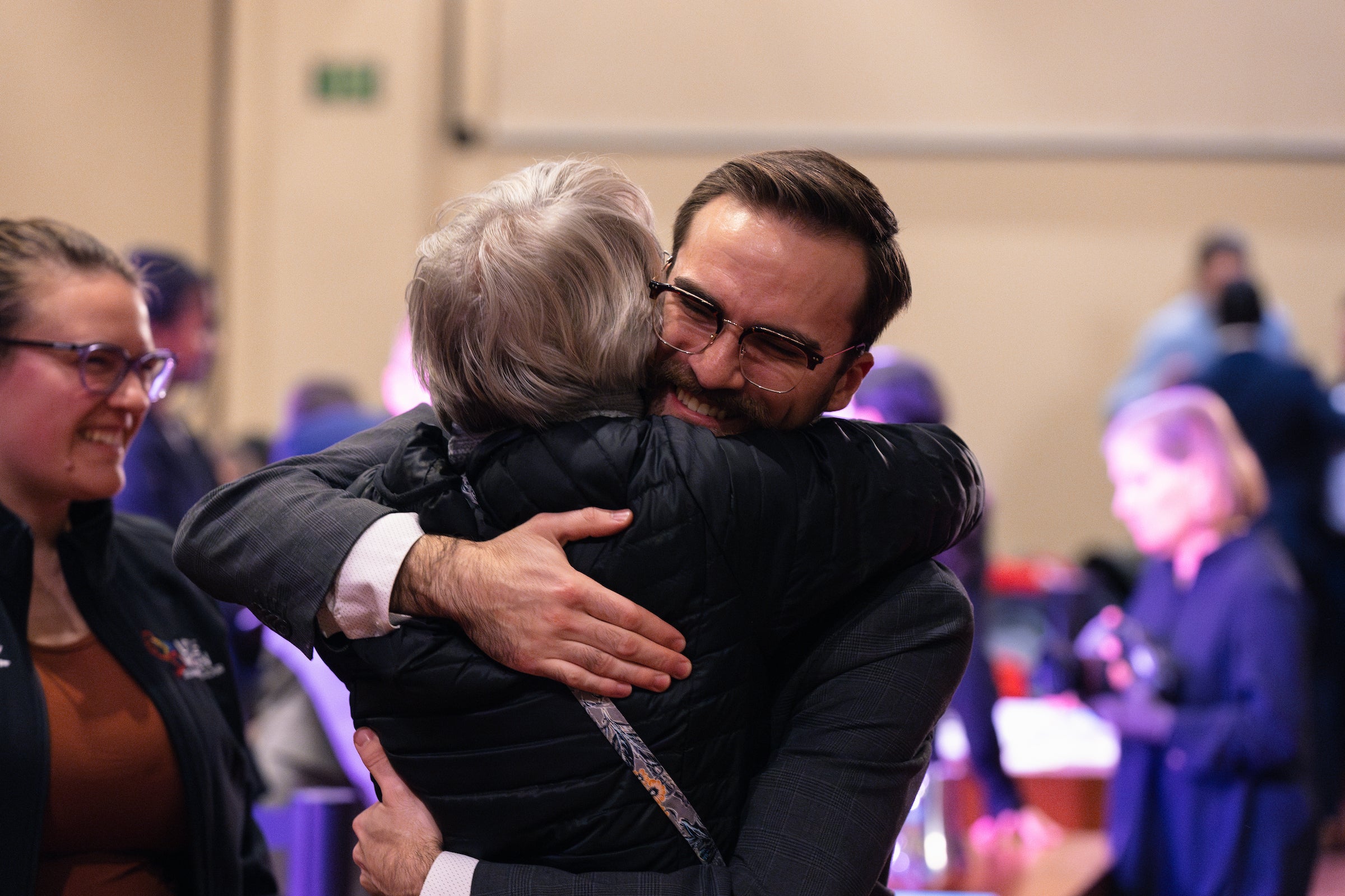 A team member and another person embrace following the event.