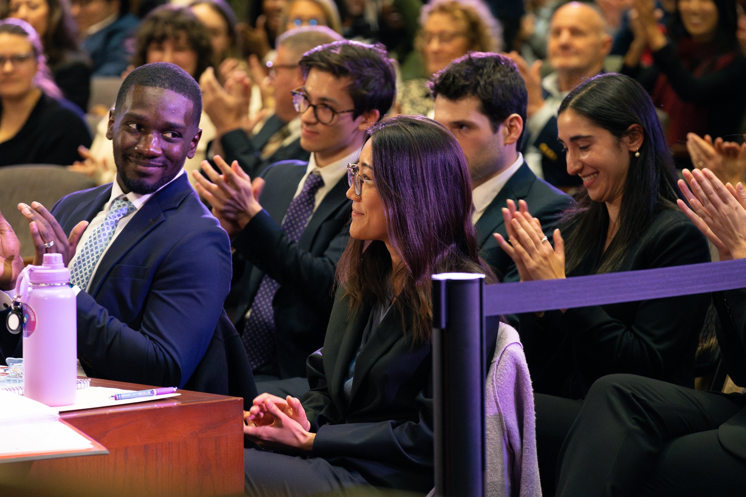 Team members clap as an oralist is named best oralist.
