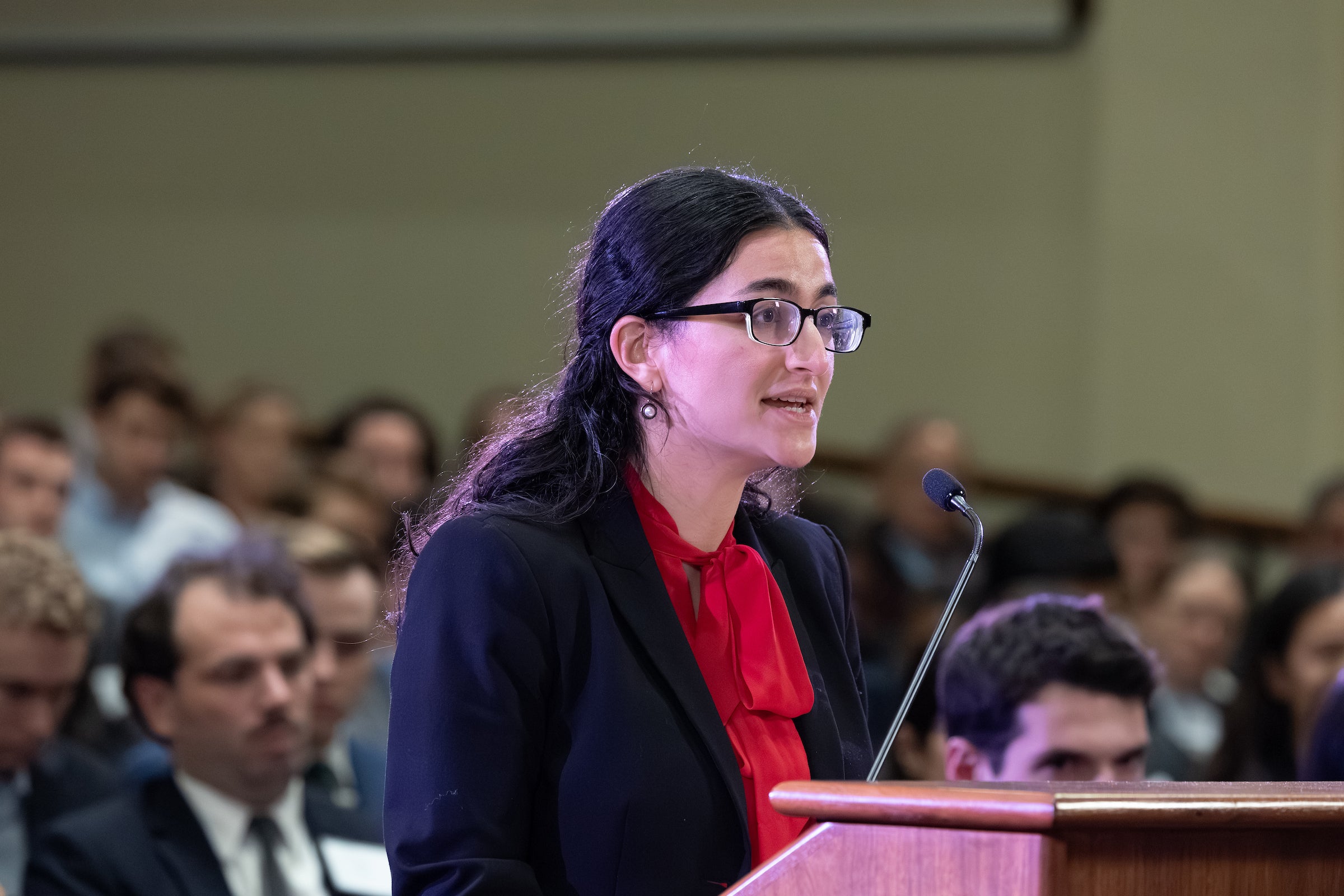 A woman speaks from a podium.