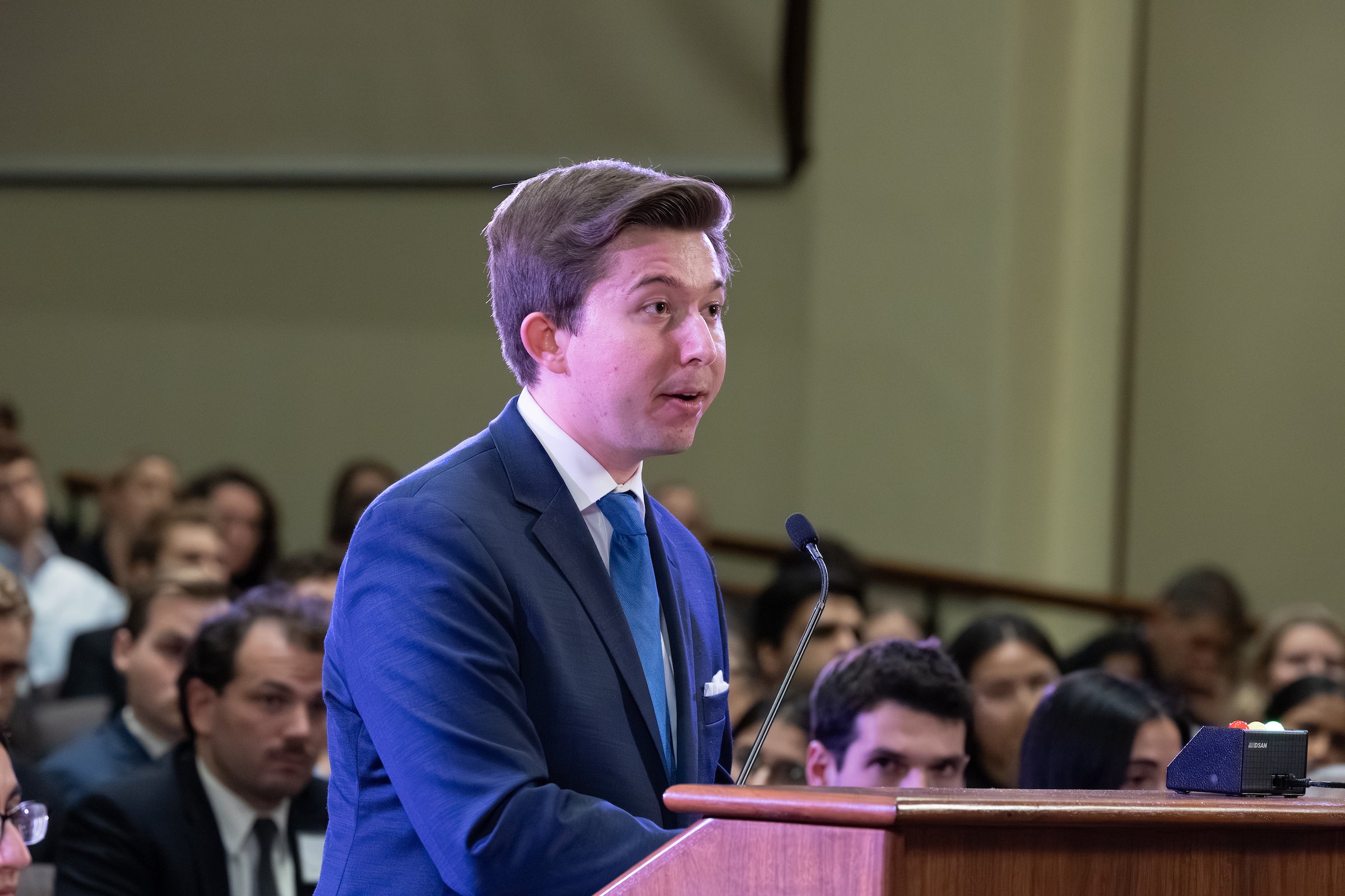 A close up of a man speaking at at podium.
