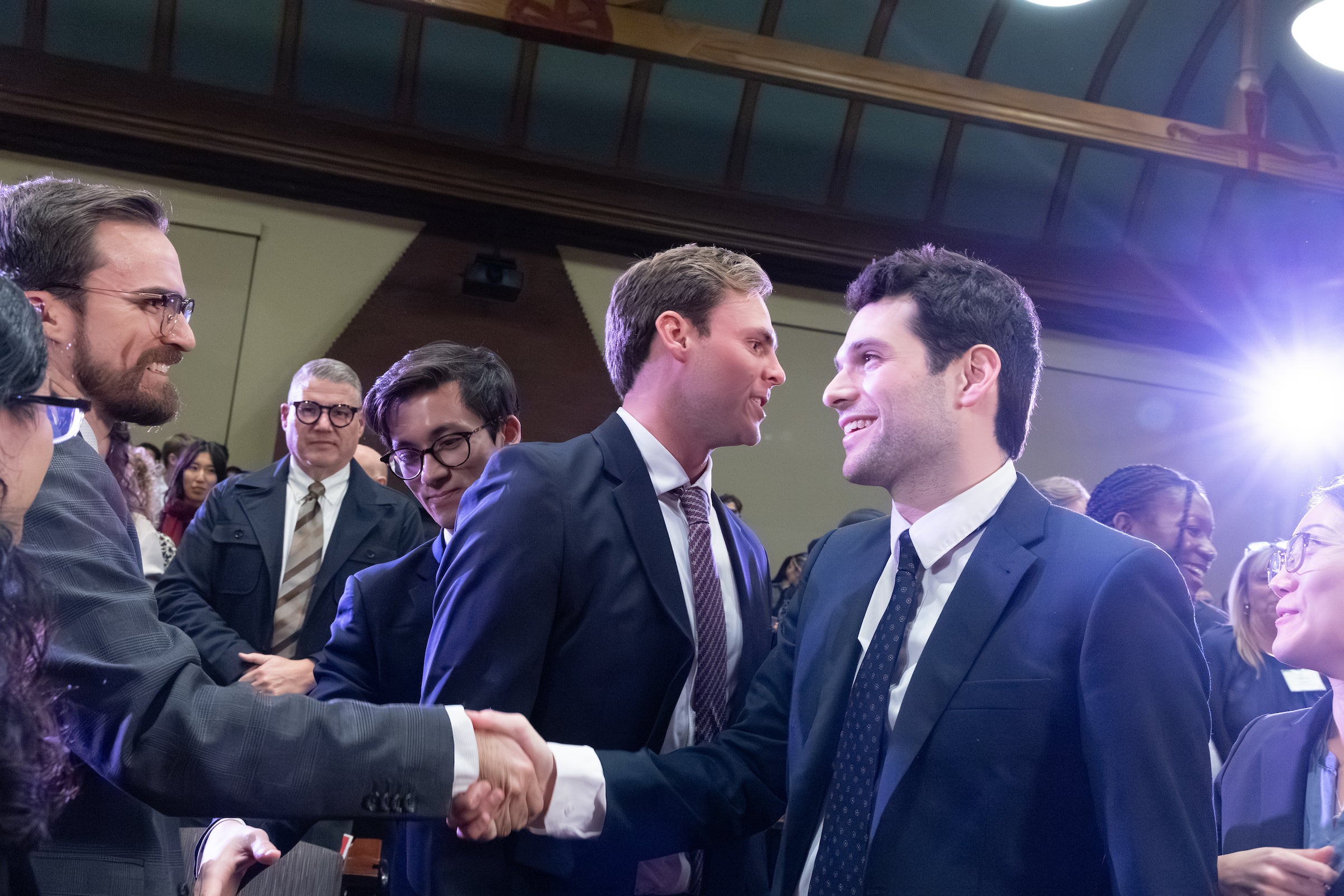 Students shake hands.