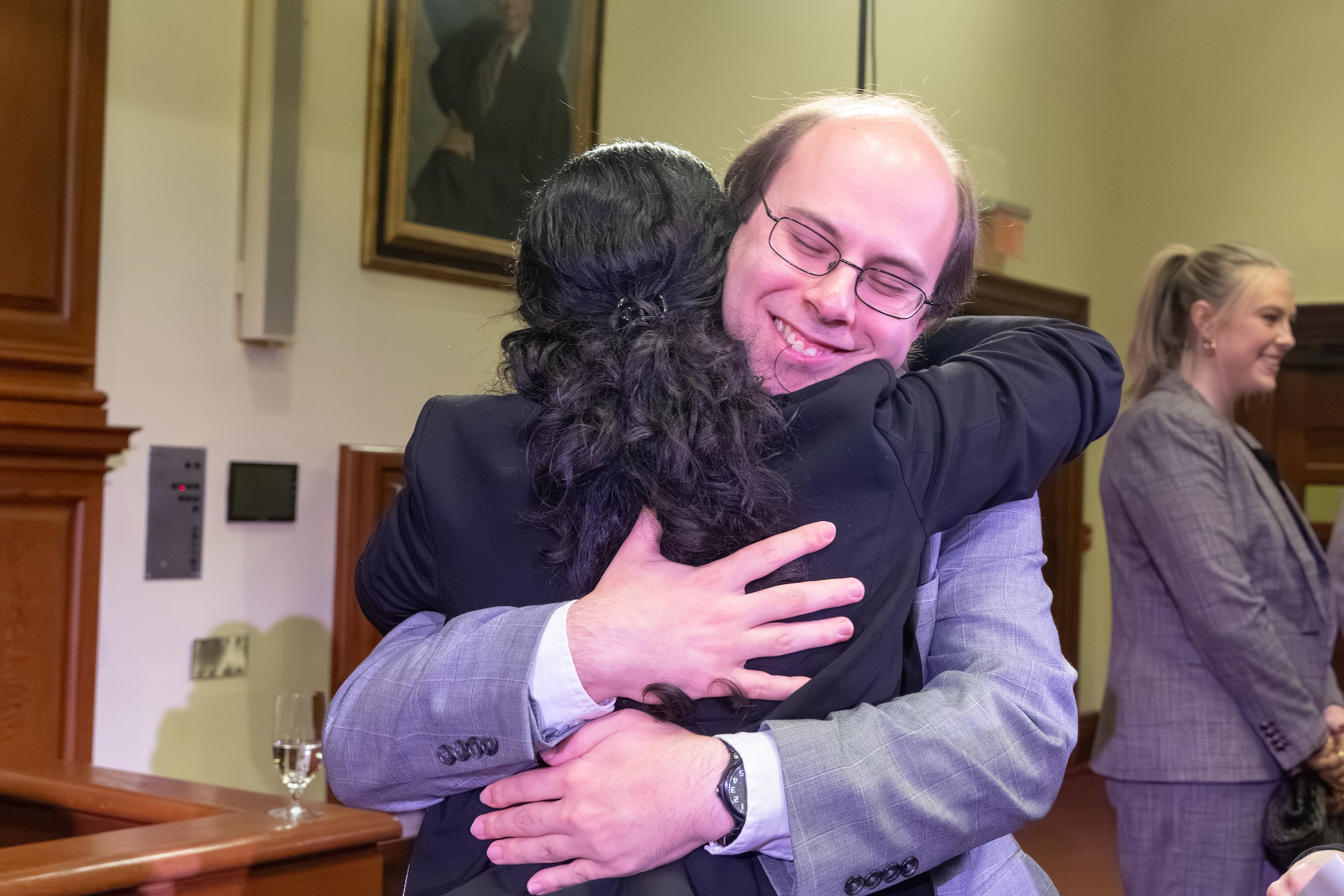 An individual at the competition gives a hug to one of the oralists.