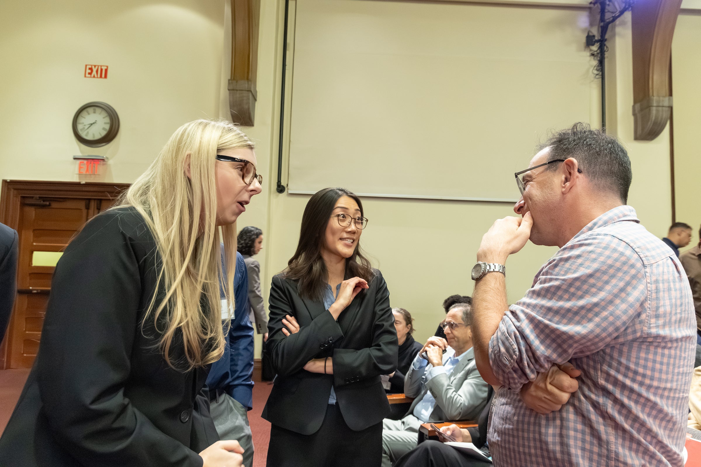 A professor speaks with students.
