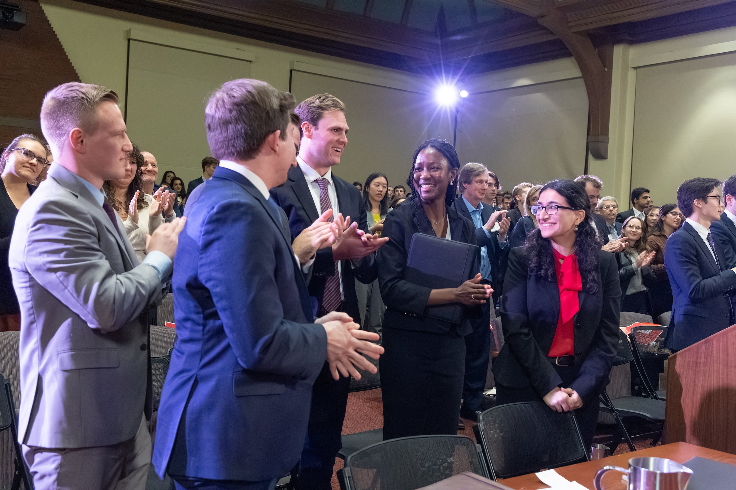 Team members standing in a row in the courtroom share a happy moment.