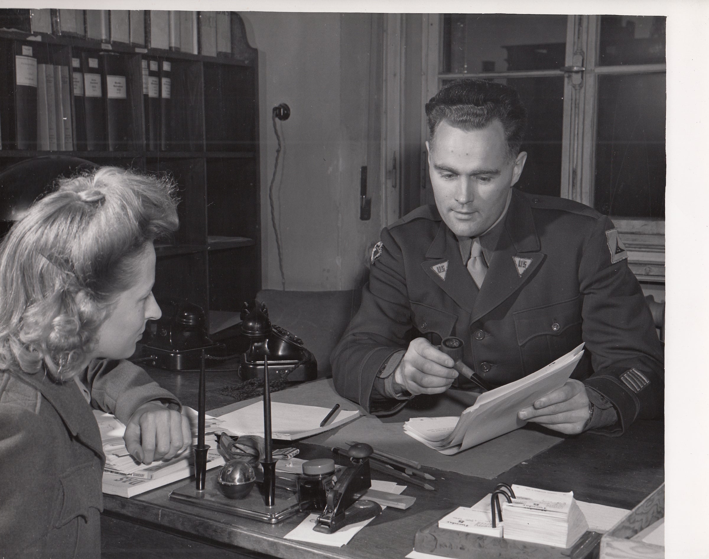 Drexel A. Sprecher, prosecutor and director of publications for the Nuremberg Trials, reviewing documents with another person.