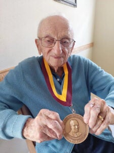 Benjamin Ferencz displays his Harvard Law School Medal of Freedom at the age of 102.